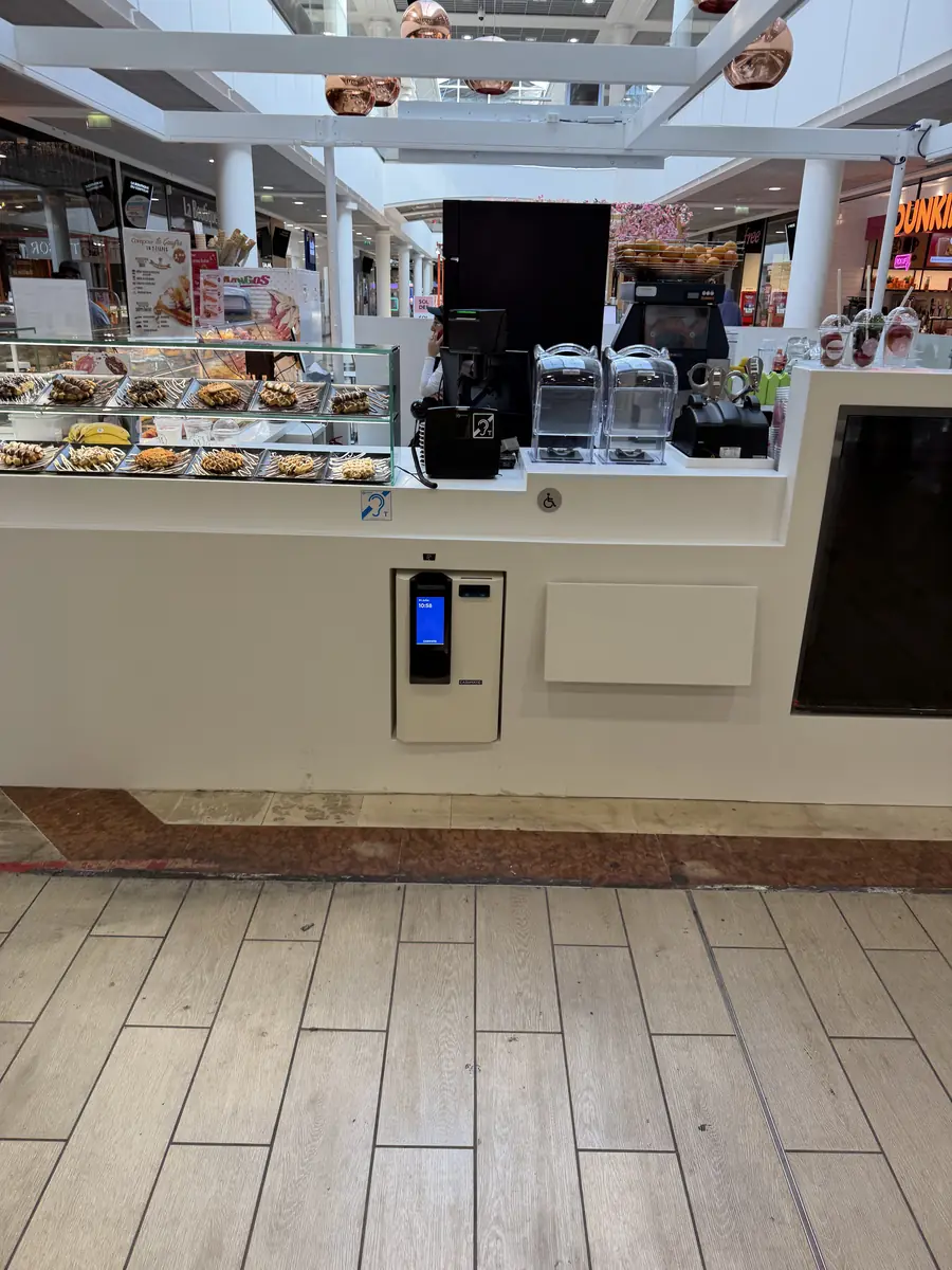 Monnayeur intégré dans le comptoir d'un kiosque de restauration, côté client