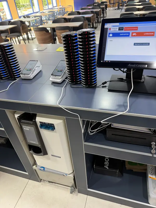 Monnayeur installé sous le plan de caisse d'un self-service