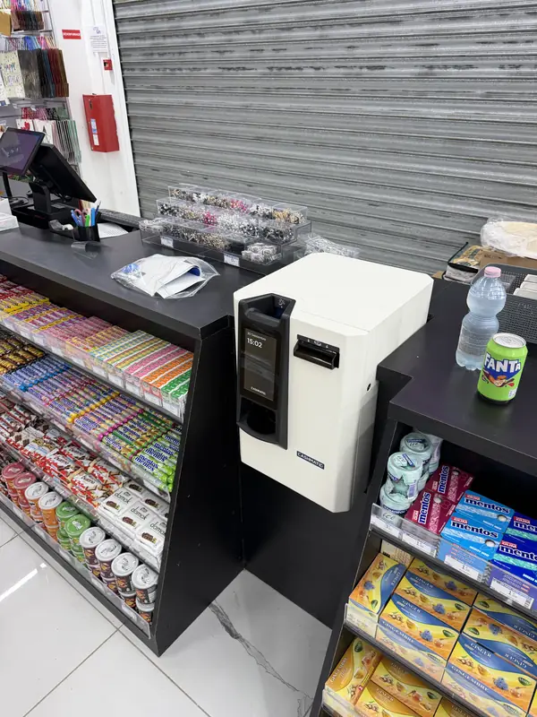 Monnayeur posé sur le comptoir d'un commerce de proximité